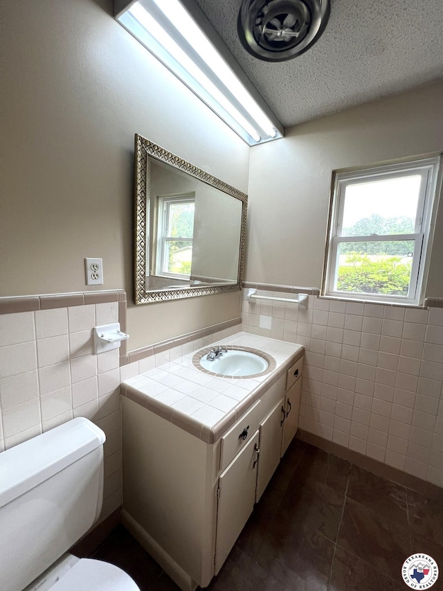 6 Arnold Dr, Texarkana, AR 71854 - half bath with tile walls, toilet, vanity, a wainscoted wall, and a textured ceiling