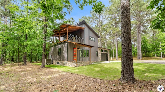 228 Old Factory Site Rd, Murfreesboro, AR 71958 - view of front of property with a balcony, board and batten siding, a front lawn, and a garage