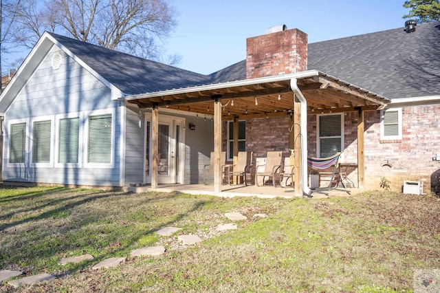 back of property featuring a patio area and a yard