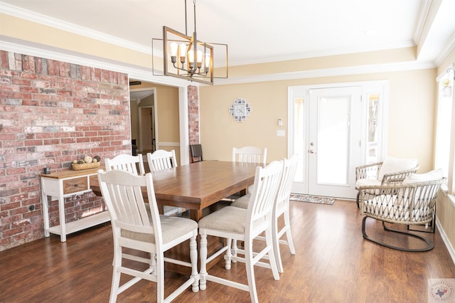 dining area featuring dark hardwood / wood-style floors, crown molding, and a notable chandelier