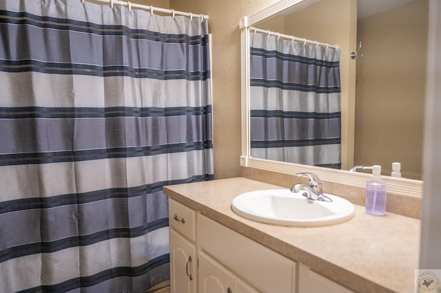 bathroom featuring curtained shower and vanity