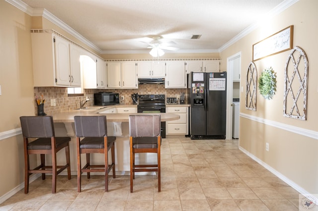 kitchen featuring black appliances, tasteful backsplash, a kitchen breakfast bar, sink, and kitchen peninsula