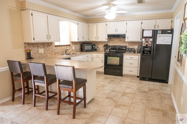 kitchen with black appliances, white cabinets, and kitchen peninsula