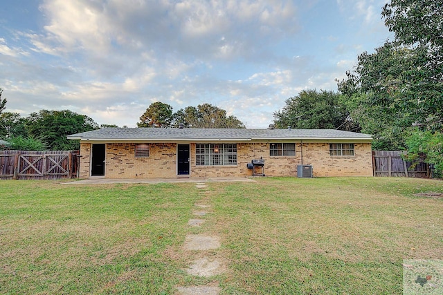 view of front of house featuring central AC unit and a front yard