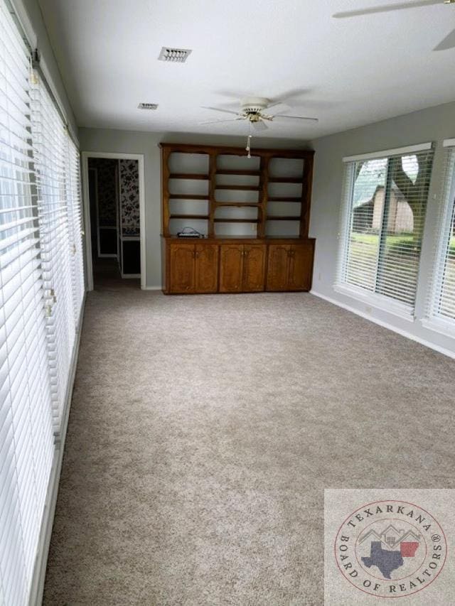 unfurnished living room with ceiling fan and light carpet