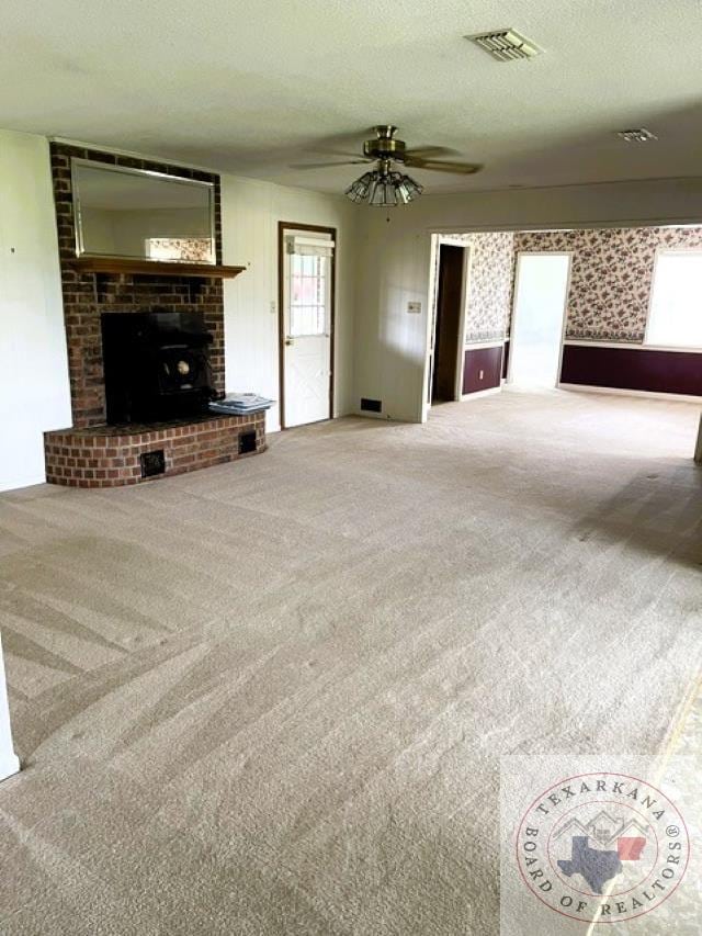 carpeted living room featuring ceiling fan and a textured ceiling