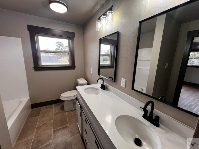 bathroom with a wealth of natural light, toilet, and vanity