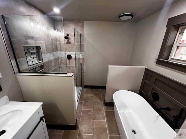 bathroom with vanity and shower with separate bathtub