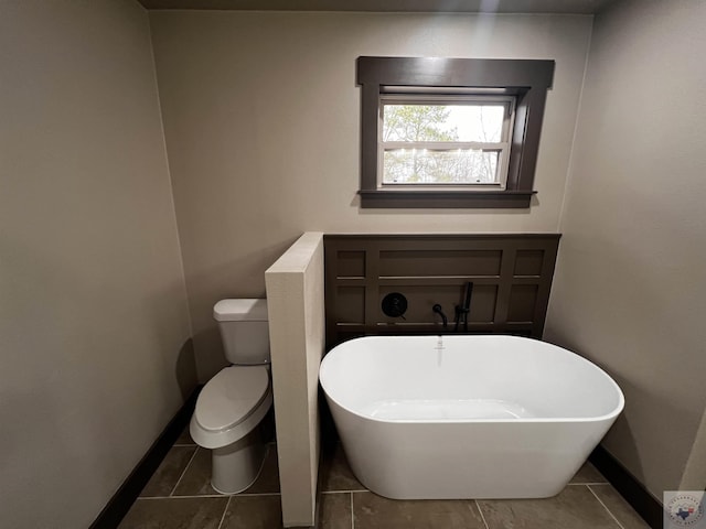 bathroom featuring toilet, tile patterned floors, and a bathing tub