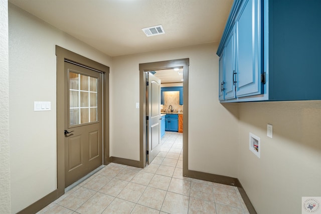 washroom featuring washer hookup, cabinet space, visible vents, light tile patterned flooring, and a sink