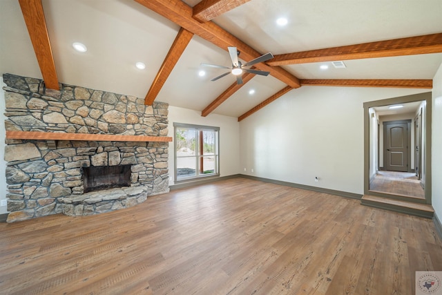 unfurnished living room with vaulted ceiling with beams, a fireplace, wood finished floors, and visible vents