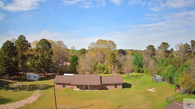 back of property with brick siding and a lawn