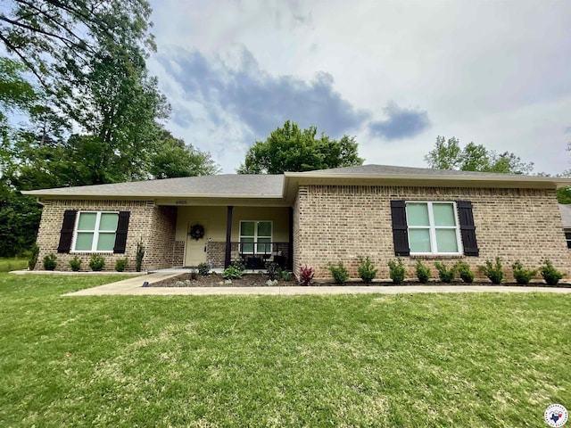 ranch-style home featuring brick siding and a front yard