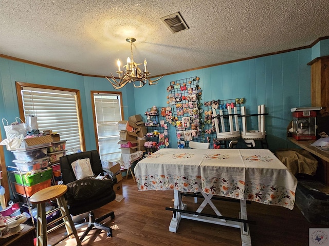 bedroom featuring an inviting chandelier, ornamental molding, dark wood-type flooring, and a textured ceiling