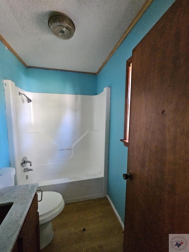 full bathroom featuring toilet, a textured ceiling, bathtub / shower combination, and vanity