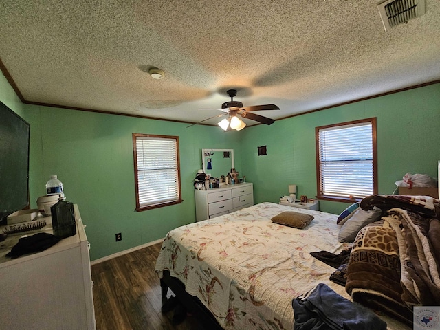 bedroom featuring ceiling fan, a textured ceiling, dark hardwood / wood-style flooring, and ornamental molding