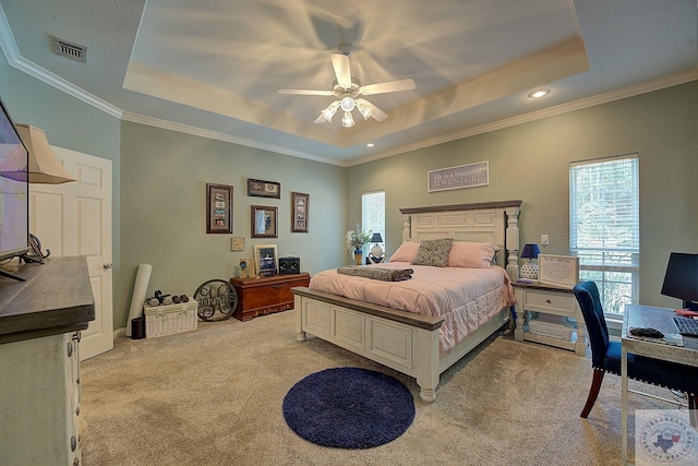 bedroom featuring ceiling fan, light colored carpet, crown molding, and a tray ceiling