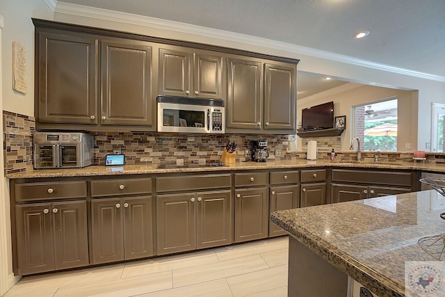 kitchen with sink, backsplash, dark stone countertops, and black electric cooktop