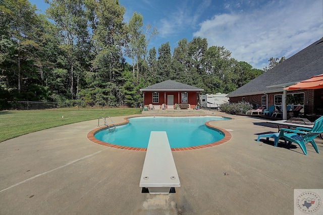 view of swimming pool featuring a lawn, a diving board, an outbuilding, and a patio