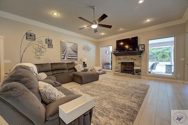 living room with ceiling fan, crown molding, and a fireplace