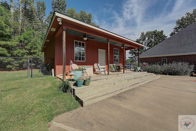 view of front of house with ceiling fan, a patio, and a front lawn