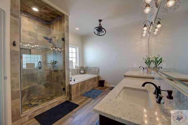 bathroom featuring hardwood / wood-style flooring, vanity, ornamental molding, and separate shower and tub