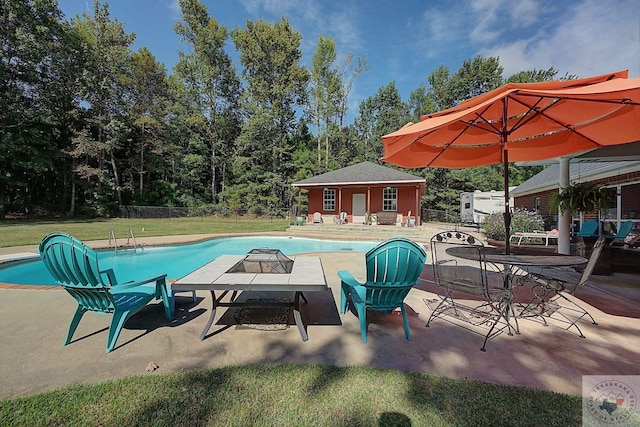 view of swimming pool featuring a yard, a patio, and an outdoor structure