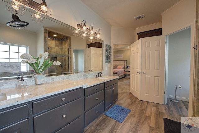 bathroom featuring vanity, hardwood / wood-style flooring, ornamental molding, and an enclosed shower