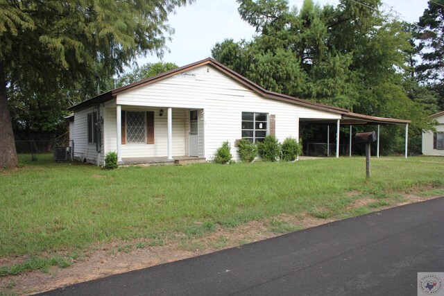 view of front of house featuring central AC, a front lawn, and a carport