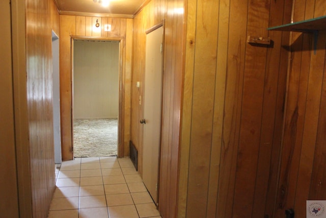 hall featuring light carpet and wood walls