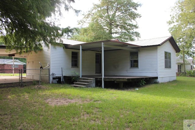 rear view of house featuring a yard