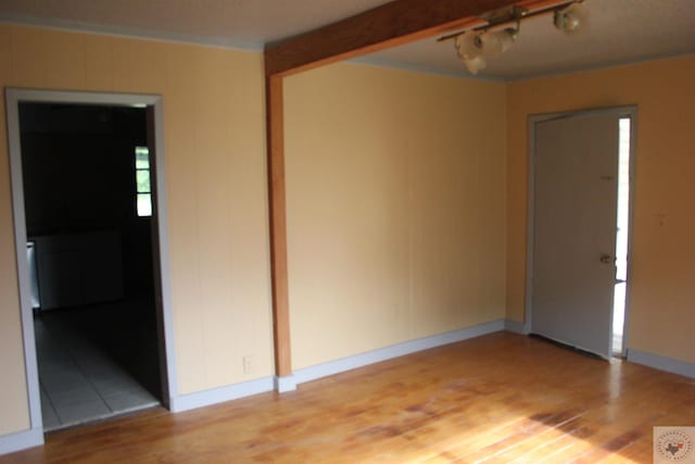 spare room with light hardwood / wood-style flooring and track lighting