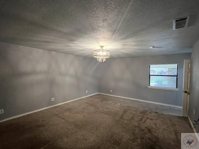 unfurnished room featuring a textured ceiling, a chandelier, and carpet