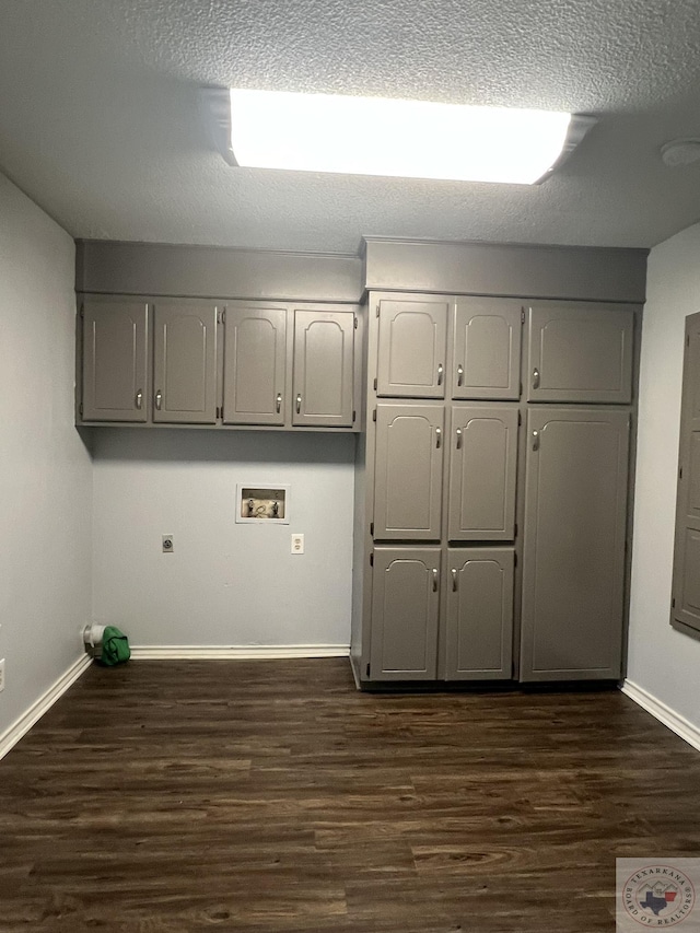 washroom featuring washer hookup, electric dryer hookup, dark hardwood / wood-style flooring, and cabinets