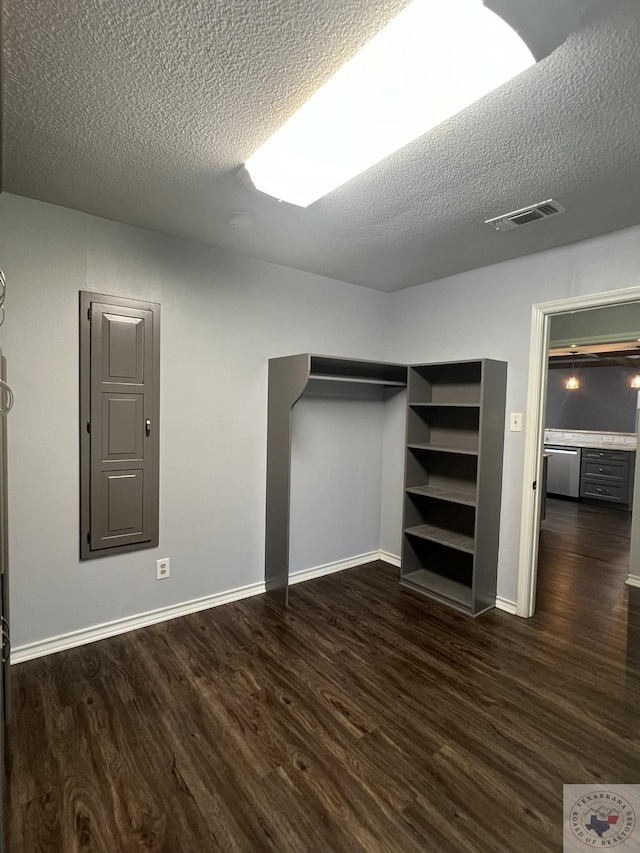 interior space with a textured ceiling and dark hardwood / wood-style flooring