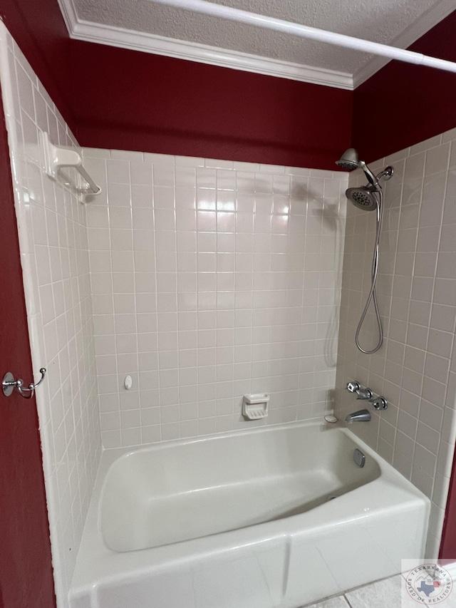 bathroom featuring a textured ceiling, ornamental molding, and tiled shower / bath