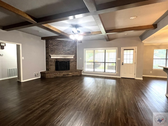 unfurnished living room with beamed ceiling, coffered ceiling, a brick fireplace, dark hardwood / wood-style flooring, and ceiling fan