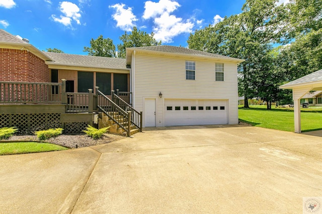 view of front of house with a garage, a front yard, a sunroom, and a deck