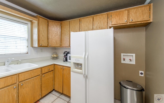 kitchen with sink, white refrigerator with ice dispenser, and light tile patterned floors