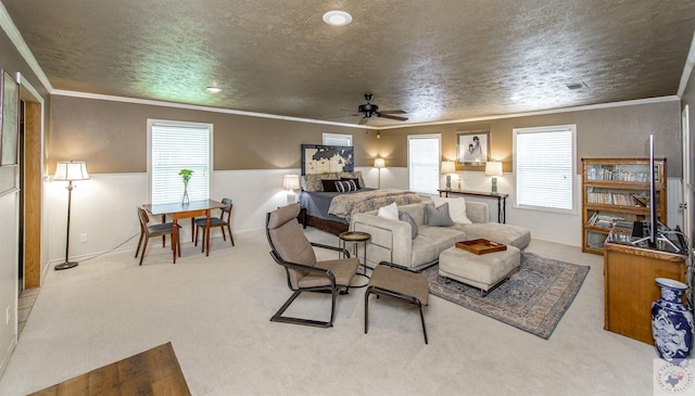 carpeted living room with ceiling fan, a healthy amount of sunlight, crown molding, and a textured ceiling