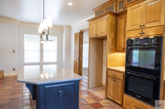 kitchen featuring pendant lighting, light stone counters, a center island, ornamental molding, and black double oven