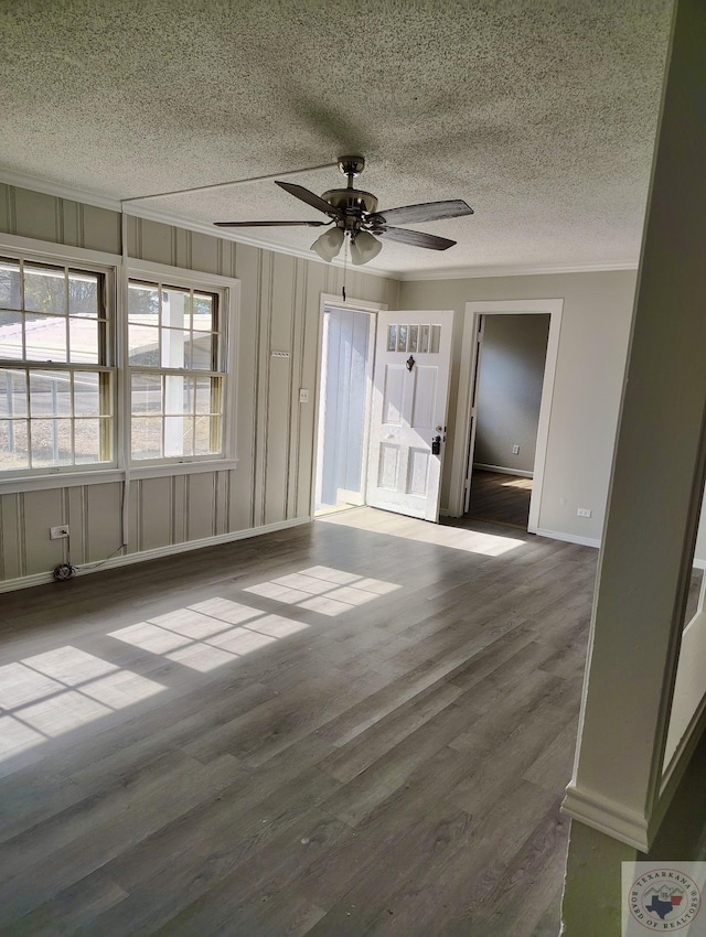 spare room featuring hardwood / wood-style flooring, a textured ceiling, ceiling fan, and ornamental molding