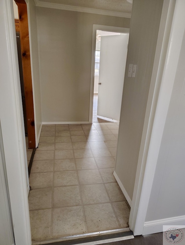 hallway featuring arched walkways, baseboards, and crown molding