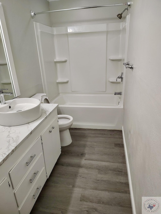 bathroom featuring shower / bathtub combination, toilet, vanity, wood finished floors, and baseboards