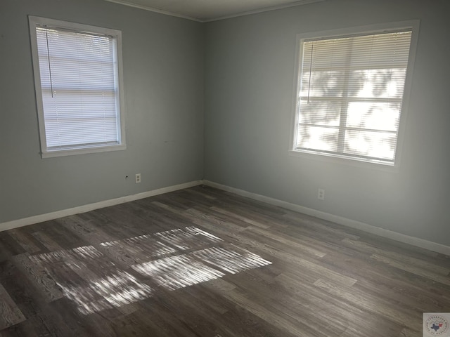 unfurnished room featuring dark wood-type flooring and crown molding