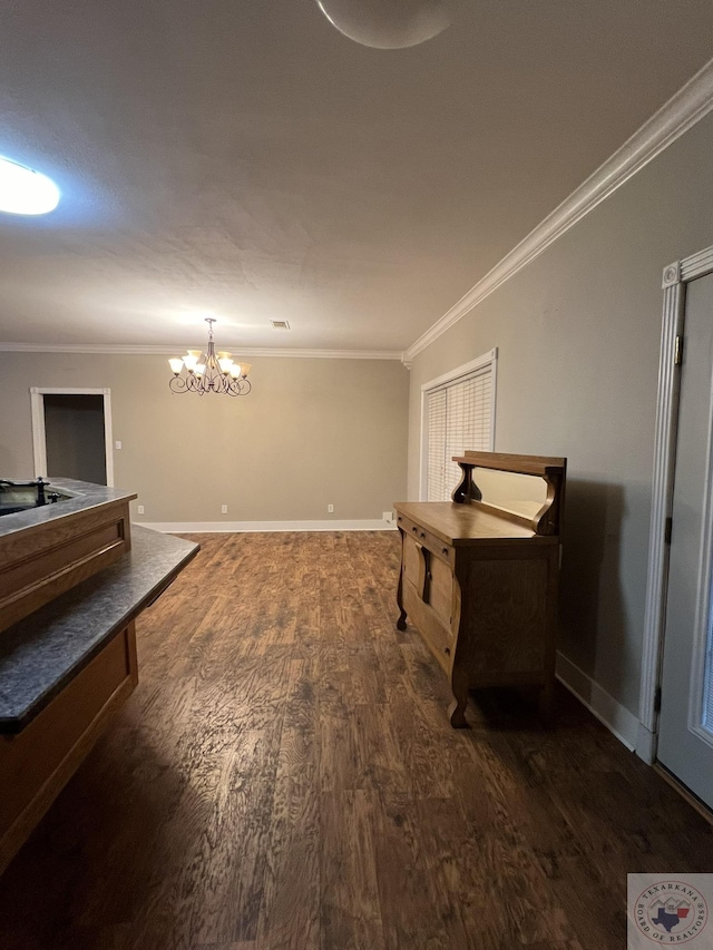 interior space featuring dark wood-type flooring, a notable chandelier, and ornamental molding