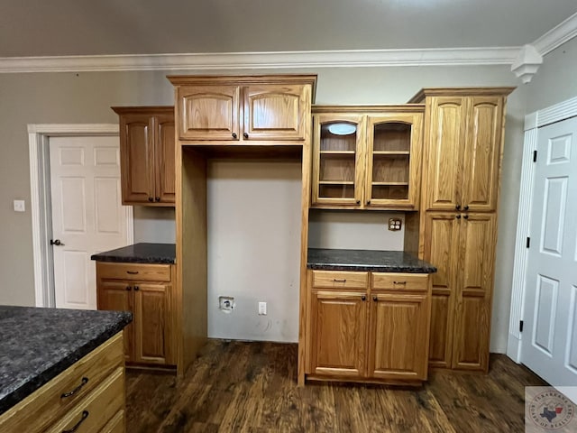 kitchen featuring dark hardwood / wood-style flooring, dark stone counters, and ornamental molding