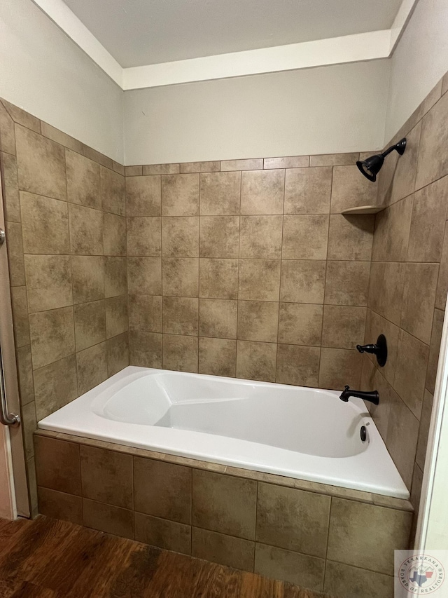 bathroom featuring hardwood / wood-style flooring and tiled shower / bath