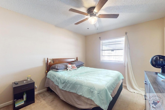 bedroom with ceiling fan, baseboards, a textured ceiling, and light colored carpet