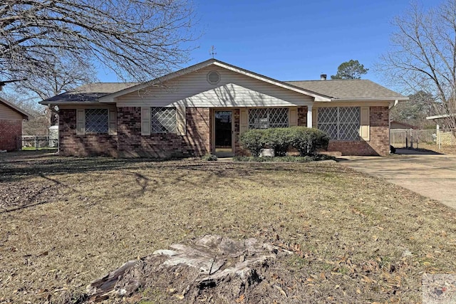 ranch-style house with brick siding, a front lawn, and fence